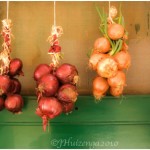 Hanging onions on green door