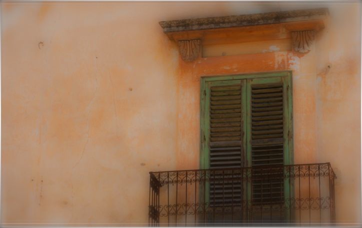 Green shutters in apricot wall, Sicily, by Jann Huizenga
