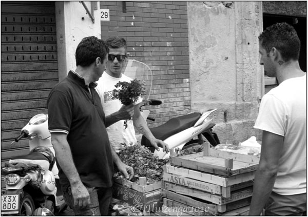 Three men discussing parsley in Siracusa, Sicily, copyright Jann Huizenga
