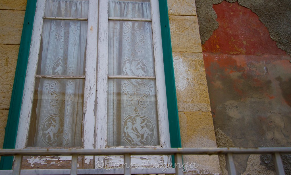 Lace with Cherubs in Window in Southeast Sicily, copyright Jann Huizenga