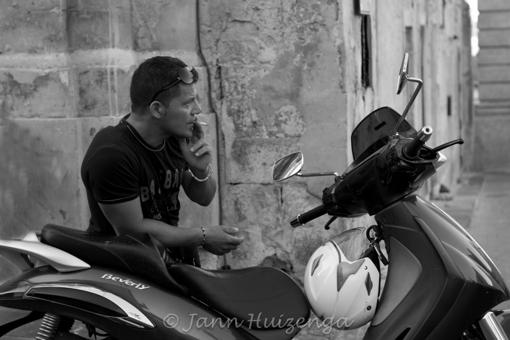 Sicilian Man in Noto Leaning on Motorcycle, copyright Jann Huizenga