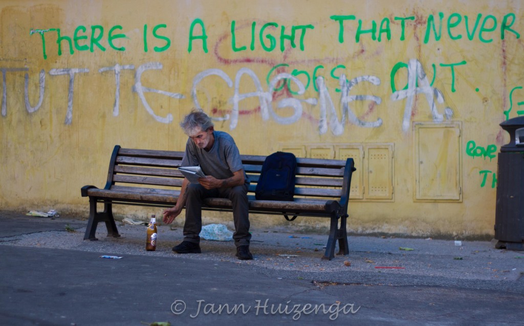 Roman Man on Bench under Graffiti; copyright Jann Huizenga